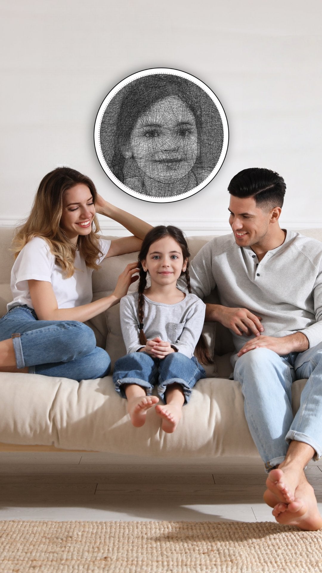 A couple sitting on either side of their daughter, with a String Art portrait of the daughter hanging on the wall behind them.
