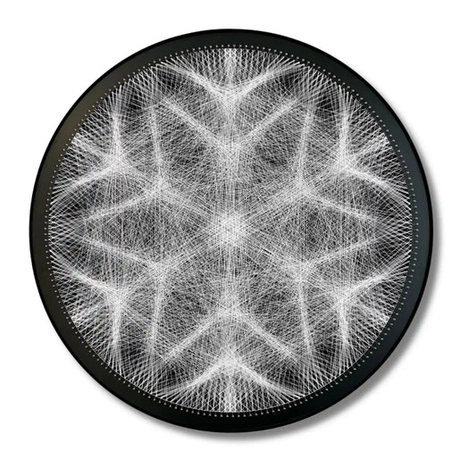 Finished string art design of a snowflake from the White Collection using black board and white strings